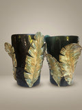 Par de vasos de cerâmica pretos decorados com folhas de Ravenala verdes e amarelas